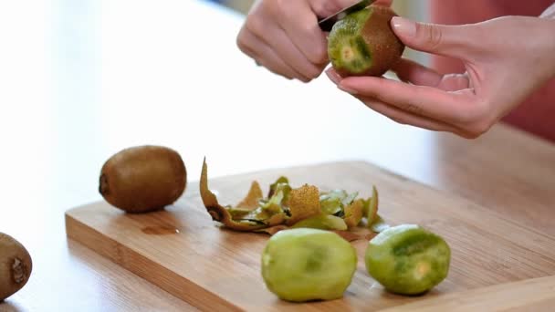 Woman Cleans Skin Knife Kiwi Wooden Cutting Board Close — Stock Video