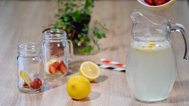 Making fresh homemade strawberry lemonade in a jug. — Stock Video
