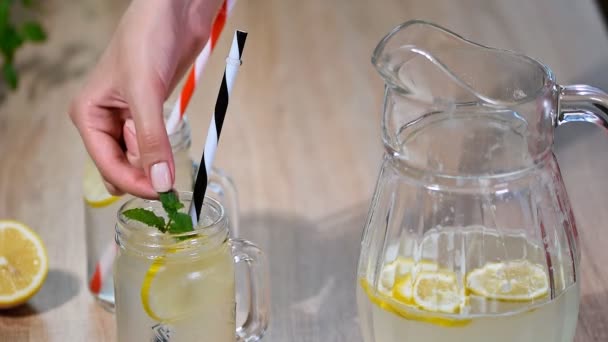 Dos vasos de tarro de albañil de limonada casera sobre un fondo de madera . — Vídeo de stock