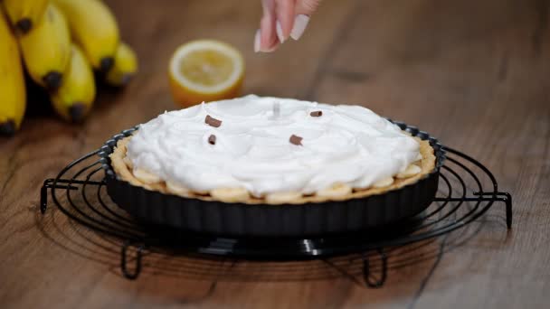 Bananenkuchen mit Bananen, Schlagsahne, Schokolade Stück Bananenkuchen schneiden. — Stockvideo