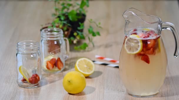 Limonata çilek, limon ve buz cam sürahi. — Stok video