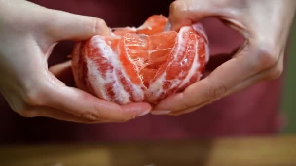 Female hands cleanse the grapefruit. — Stock Video