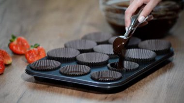 Çikolata muffins yapma bir kadın. Dökülen kek karışımı içine pan