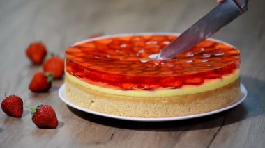 Jöle ile çilekli pasta bir parça kesme.