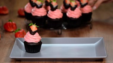 Ahşap bir masa üzerinde çilek ile çikolata cupcakes.