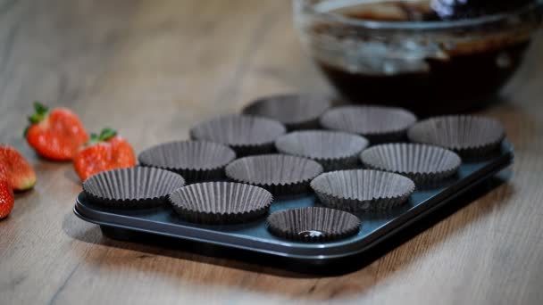パンにケーキ ミックスを注ぐ チョコレートのマフィンを作る女性 — ストック動画
