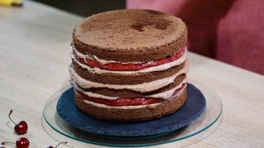 Çikolatalı kek kiraz ile hazırlanması. Pastayı nem için tatlı şurubu ile ıslatılır.