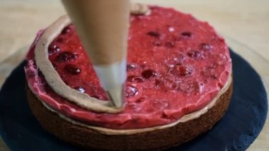 Tanınmayan kadın pasta yemek iştah açıcı katman kek mutfak üzerine sıkma krem çikolata.