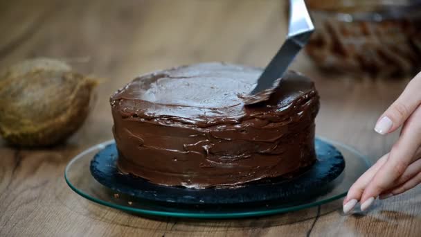 Кондитер накрывает торт шоколадным кремом . — стоковое видео
