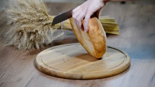 Mujer cortando pan en tabla de madera. Pastelería. Producción de pan . — Vídeo de stock