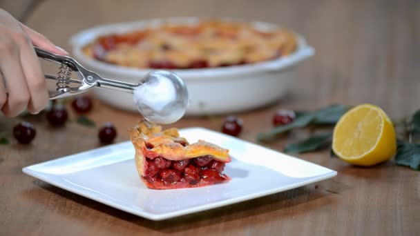 Tranche de tarte aux cerises avec une cuillère de crème glacée sur le dessus avec des cerises sur une assiette . — Video