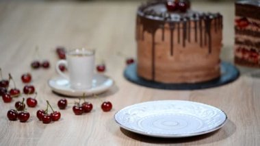 Vişneli çikolatalı pasta bir parça bir tabak içinde koyarak.
