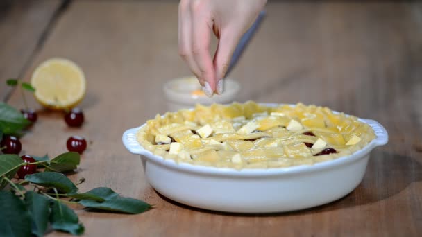 Zutaten für Kuchen mit frischem Kirschkuchen gefüllt backen. Weibchen bereiten Kirschtorte zu. Die Torte mit Zucker bestreuen — Stockvideo