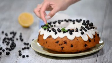 Ev yapımı limonlu kek ahşap rustik arka plan üzerinde yaban mersini ile süsleyin.