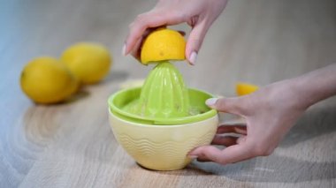 Kadın mutfakta bir limon tutarak.