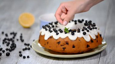 Ev yapımı limonlu kek ahşap rustik arka plan üzerinde yaban mersini ile süsleyin.