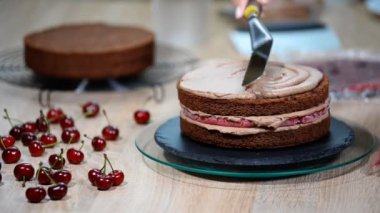 Tanınmayan kadın pasta yemek iştah açıcı katman kek mutfak üzerine sıkma krem çikolata.