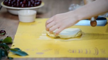Kadın el mutfak masasında çilek ile bir pasta yapmak için dışarı hamur rulo.