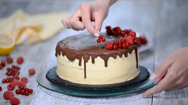 Σεφ ζαχαροπλαστικής διακοσμεί ένα κέικ με μούρα. — Αρχείο Βίντεο