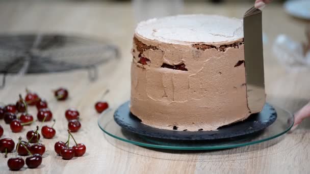 Vrouw versieren een heerlijke cake met slagroom crème. — Stockvideo