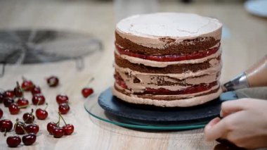 Tanınmayan kadın pasta yemek iştah açıcı katman kek mutfak üzerine sıkma krem çikolata.