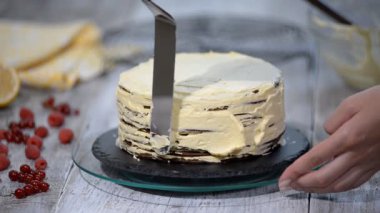 Pasta şefi kendi elleri ile bir pasta yapar ve onu çilek ile süsle.