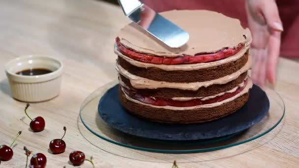无法辨认的女性糕点厨师挤压巧克力奶油在开胃层蛋糕厨房. — 图库视频影像
