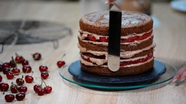 Tanınmayan kadın pasta yemek iştah açıcı katman kek mutfak üzerine sıkma krem çikolata.