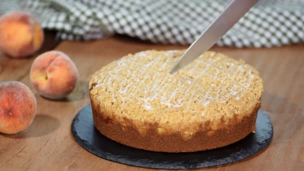 Snij een stuk van peach crumble taart. — Stockvideo