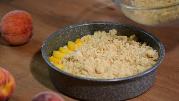 The process of preparation of peach crumble cake. Summer peach pie with crumb — Stock Video