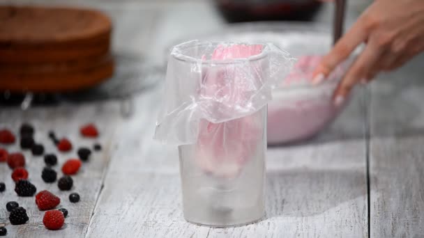 Il pasticcere mette la crema in borsa culinaria da un frullatore di bancarella . — Video Stock