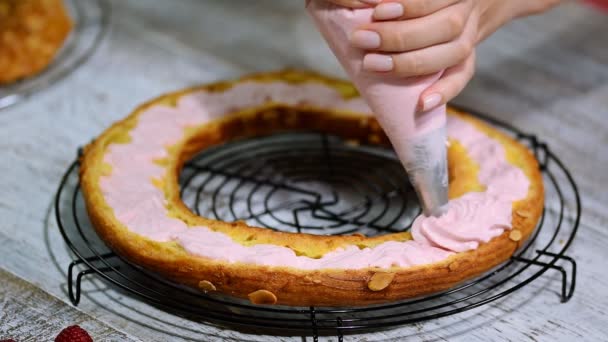Połowę ciasta Paris Brest. Tło: worka ciasta napełniania z bitą śmietaną. — Wideo stockowe