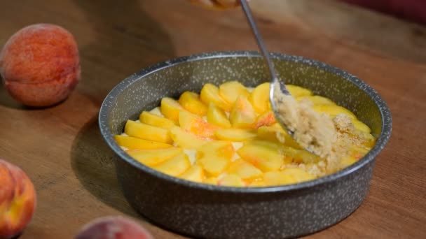 Der Prozess der Zubereitung von Pfirsich-Streuselkuchen. Sommer-Pfirsichkuchen mit Krume. — Stockvideo
