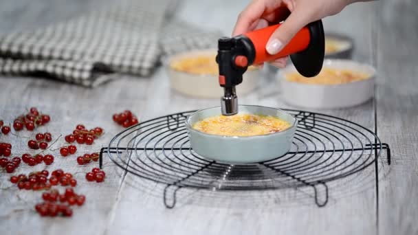 Branden gedeelte van crème brulee dessert op keuken. Heerlijk Frans dessert crème brulee — Stockvideo