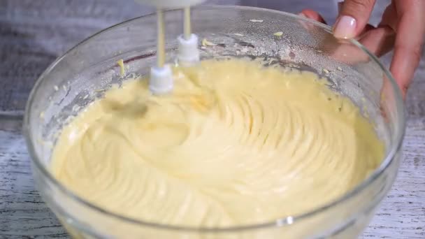 Vrouwelijke handen deeg roeren met een mixer voor cake. — Stockvideo