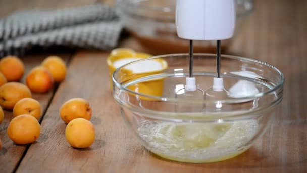 Mani femminili sbattono albumi crema con mixer nella ciotola — Video Stock