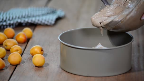 Femme versant de la pâte dans un moule. Faire un gâteau au chocolat à la maison . — Video