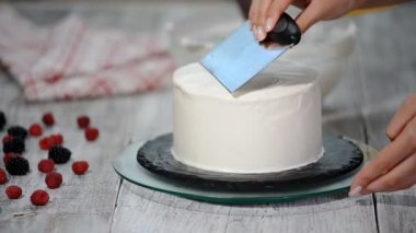 Eller tarafından beyaz spatula çikolata kek üzerine tereyağı krema bulaşması yakın çekim.