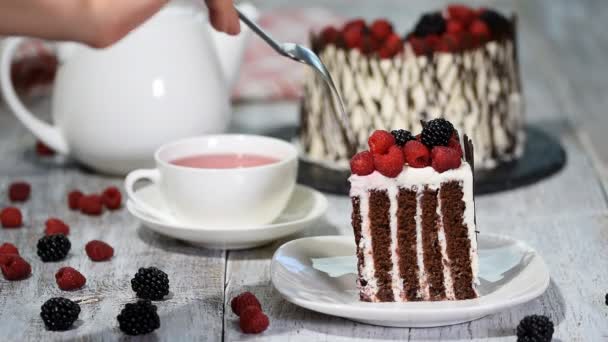 Pastel vertical rústico de moda con chocolate, crema de vainilla y bayas . — Vídeo de stock