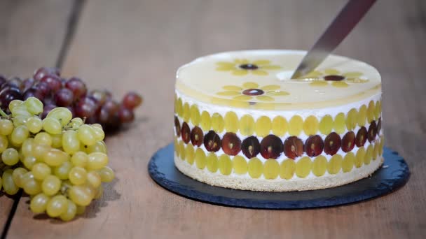 Corte com um bolo de mousse de faca com uvas. Bolo de mousse redondo decorado com uvas . — Vídeo de Stock
