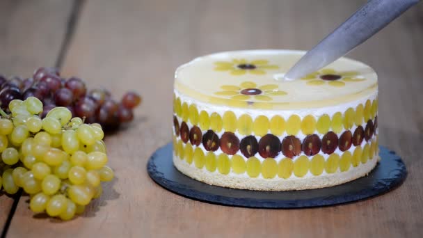 Corte com um bolo de mousse de faca com uvas. Bolo de mousse redondo decorado com uvas — Vídeo de Stock