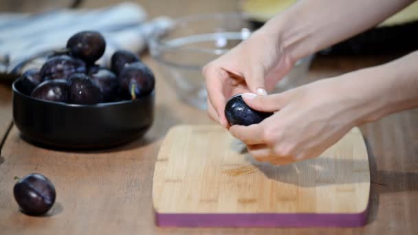 Donna che cucina e taglia prugne su tagliere in legno. Preparare cibi sani . — Video Stock