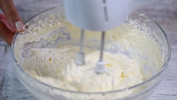 Maken van een crème voor huisgemaakte taarten. Klop met een mixer boter crème. — Stockvideo