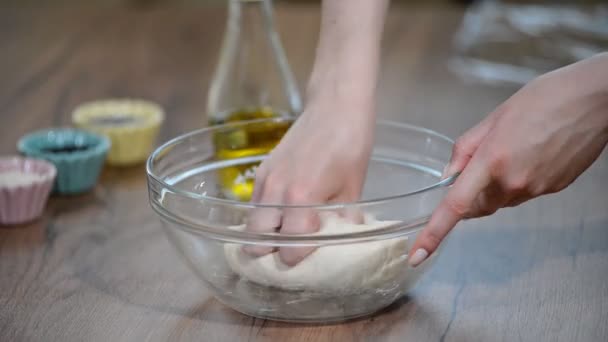 Las manos amasan la masa para pan en un tazón . — Vídeos de Stock