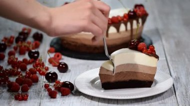 Lezzetli üç çikolatalı mousse kek parçası taze berry ile dekore edilmiştir..