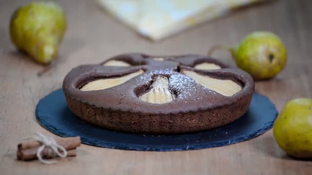 Pastel de pera de chocolate casero. Espolvorear el pastel con azúcar en polvo — Vídeos de Stock