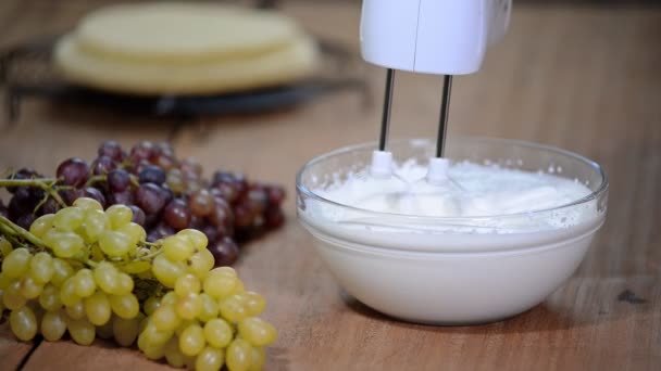 Crema batida en cuenco de cristal con batidores . — Vídeo de stock