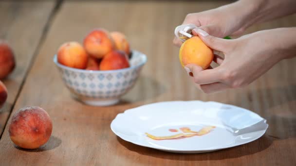 Kvinnliga händer peeling en blek persika. — Stockvideo
