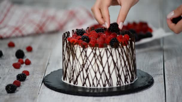 Pâtisserie chef décore un gâteau avec des baies . — Video