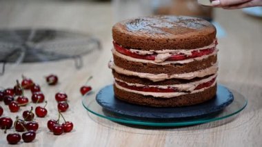 Çikolatalı kek kiraz ile hazırlanması. Pastayı nem için tatlı şurubu ile ıslatılır.